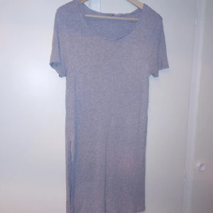  - En grå tunika med öppningar på sidorna 