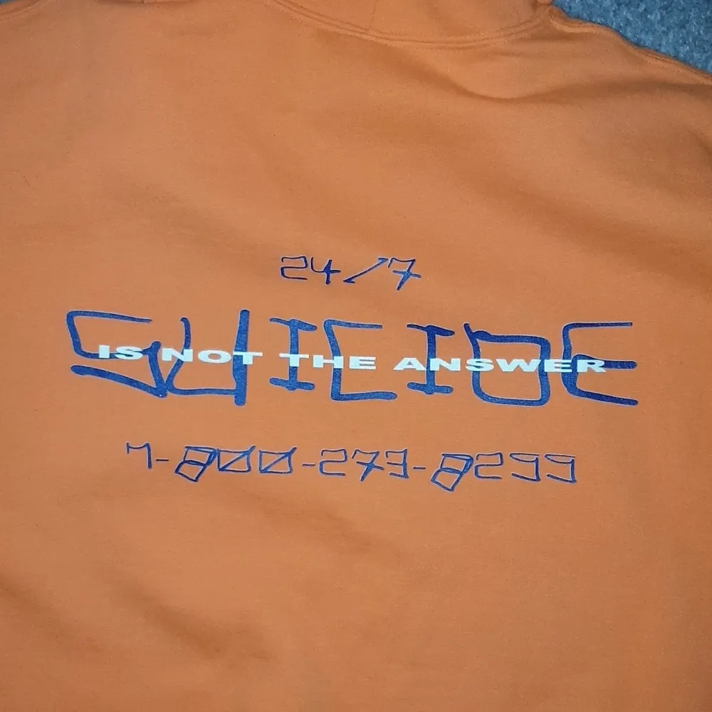 En orange hoodie från artisten, loveonfriday. Framsidan står det 