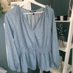 Topp - Jättesöt ljusblå topp med små små prickar på. Sitter tight i midjan och löst på armarna och där nere. Köpare står för frakt!