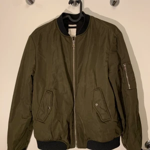 Grön bomberjacka  - Grön bomberjacka storlek M köpt på zara säljs för 50kr, sparsamt använd. Sitter snyggt, jag är storlek S. Frakt betalas av köpare 66kr skickas spårbart eller möts upp i Malmö. Tar Swish 🤝