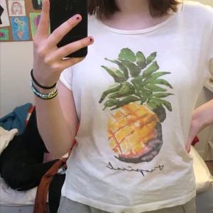 T-shirt - En vit ganska genomskillning t-shirt från H&M. Den har en jättefin ananas på framsidan!