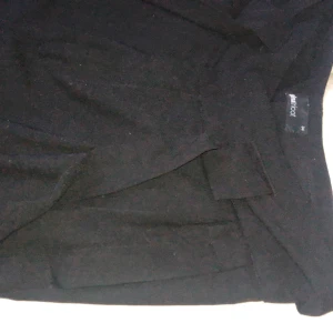 Kostymbyxor  - Svarta kostymbyxor från Gina Tricot i storlek 34, men passar 36 också! Haspen som ska fästas i metallgrejen på insidan har gått av, men det finns både knapp, dragkedja och skärp så det spelar ingen roll för passformen. Fickor på framsidan, fejkfickor på baksidan. Går även en söm på mitten längs båda benen.