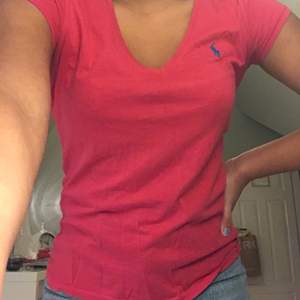 En mörk rosa V-ringad T-shirt i storlek S                       Frakten kostar 44kr