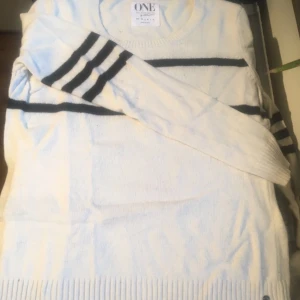  - Vit tröja med svarta ränder.