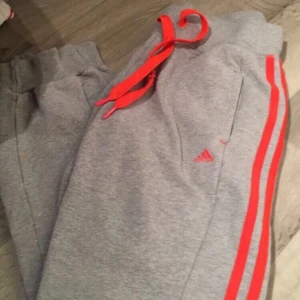  - Gråa adidas byxor med neon orange 3 sträck 