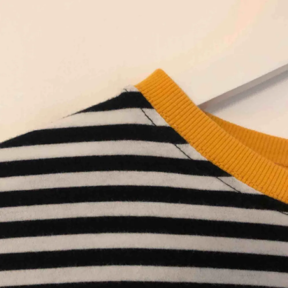 En svartrandig tröja med gula detaljer! Knappt använd och i väldigt bra skick!. Toppar.
