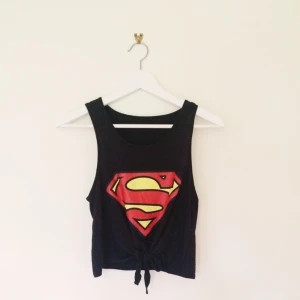 Linne med superman logga. Magkort och knytbar i fram - Linne med superman logga. Magkort och knytbar i fram