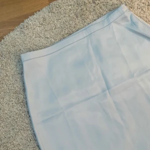  - Blå kort satinkjol i storlek 34-36 från NAKD. Aldrig använd, lappen kvar pga förstor för mig (den är mer åt 36 än 34). 