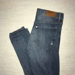 Mörkblåa jeans från H&M med slitningar i knäna i stl. W28 L32, skinny high waist
