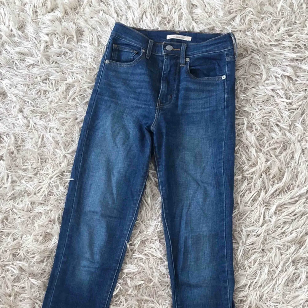 Mörkblå, tajta jeans från Levi’s i deras Mile High Super Skinny modell. Väldigt bekväma. Storlek 25 i midja och 32 i längd.. Jeans & Byxor.