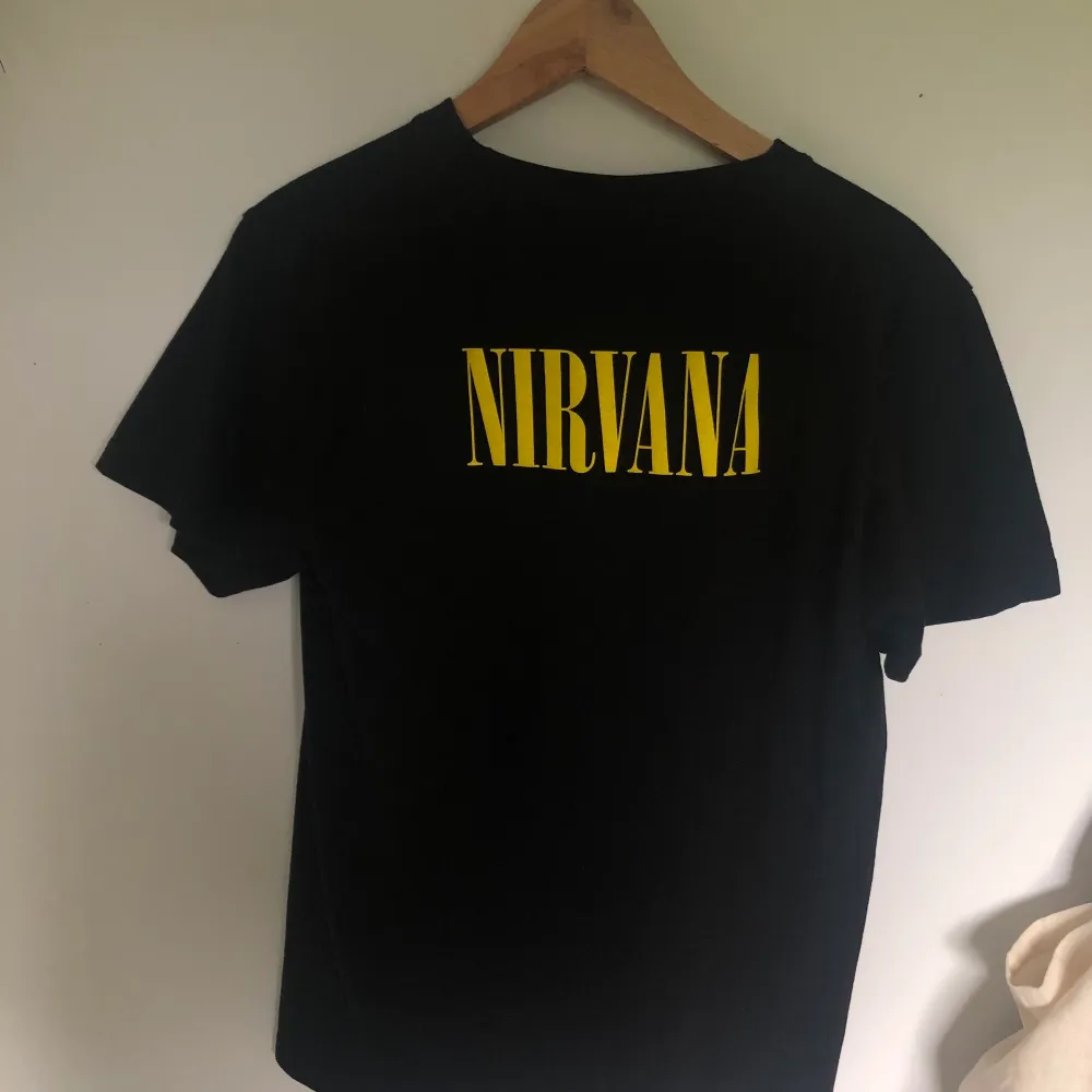 Svart Nirvana t-shirt, storlek M men den är ganska liten i storleken och inte så strechig så jag skulle säga storlek s/m. Kurt Cobain som ramlar i ett trumset på framsidan. Står nirvana med gul text på ryggen, helt oanvänd . T-shirts.