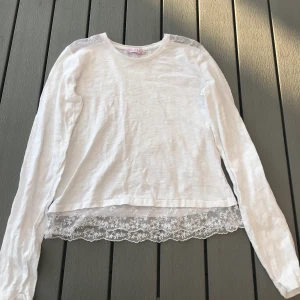 Långärmad tröja med spetts storlek XS - En fin vit tunn långärmad tröja med vit spetts på axlar och i slutet av tröjan. Den är i storlek 158,164 som är ungefär som en XS. Jag har endast använt den någon gång så den är som ny. (Frakten ingår i priset)