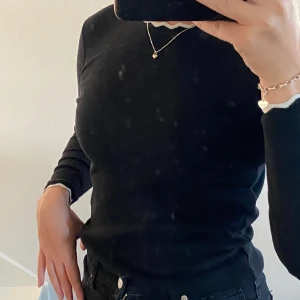 Svart tröja med vita detaljer - Svart tröja med vita detaljer på armändarna och vid halsen ifrån zara i storlek s, frakt ingår ej.