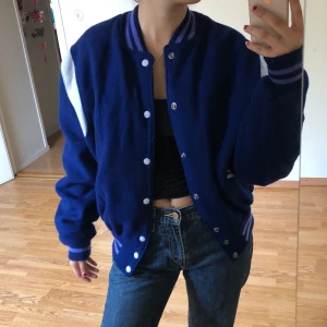 Collegejacka  - En blå retro collegejacka med vita detaljer, köpt secondhand men endast använd ett fåtal gånger av mig. Jag brukar bära S men jackan är i M.