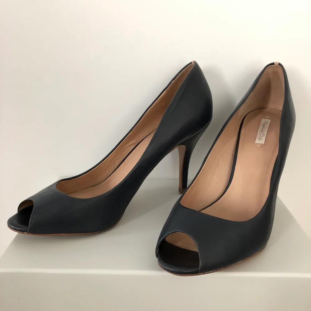 Dark blue with nude strip on the heel. Open toe and very comfortable. Looks great on any occasion . Skor.