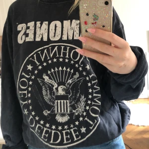Grå tjocktröja med Ramones tryck - Tröja med bandtryck Ramones, köpt second hand. Ganska tunt material men väldigt skön. Den är väldigt stor på mig som har s men går att vika upp ärmarna och stoppa in i byxorna utan att det blir klumpigt. Kan mötas i Stockholm annars betalar köpare frakt. 