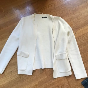 Finare kofta - Oanvänd lite tjockare kofta från GinaTricot. Fickor på båda sidorna. Vit. En liten fläck på ena armen.