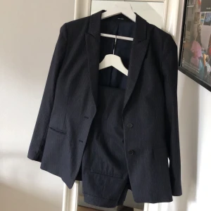 Mörkblå kritrandigt kostymset från Tiger - Mörkblå kritrandigt kostymset från Tiger of Sweden,  använt 3 gånger, säljer då byxorna blivit för små! nypris ca 5000kr! Kan skicka fler bilder vid intresse! Säljes endast tillsammans