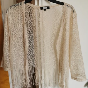 Virkad kofta - Söt virkad kofta med fransar. Väldigt tunn. Fin att hö över en klänning. 