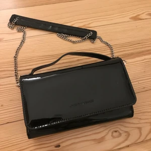 Clutch/plånbok/väska Carin Wester - Liten väska i svart lack från Carin Wester. Perfekt för festligare tillfällen eller ja inte vet jag! Aldrig använd, men har en liten liten skavank på en kant som knappt syns. Köpt för 499! 250 kr inkl frakt. 