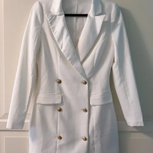 MISSGUIDED Blazer Dress White 36 - Klänning i blazermodell från MISSGUIDED. V-ringning, långärmad. Vit, dubbelknäppning, guldknappar. Storlek 36. True to size. Kan bäras som off-shoulder. Jättefint skick. Använd en kväll, därefter kemtvättad. Nypris 700:-