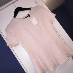  - Säljer en helt oanvänd topp för halva priset från H&M i storlek 40! Ljusrosa med volanger