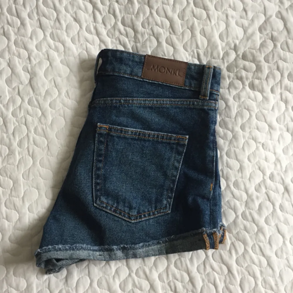 Snygga blåa jeansshorts från Monki. Sparsamt använda då de aldrig riktigt kommit till användning. Står storlek 25 men sitter som 26-27!🌻. Shorts.
