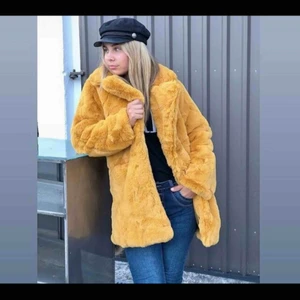  - Lyxig senapsgul fuskpäls från Tessie, väldigt fint skick, använd endast 1 gång så den är som ny! På den första bilden finns det en mer tydlig bild på hur den sitter på modellen samt färgen!   Ordinariepris: 1200:-