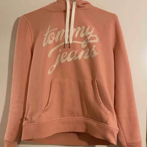  - Rosa hoodie från Tommy Jeans i storlek L, sitter som en M!  Hoodien är i bra kvalité & i fint skick!