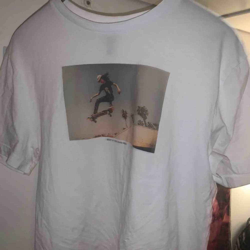 Vit t-shirt från Monki eller weekday (minns ej) med motiv. Perfekt skick. Bilden föreställer en man på en skateboard och texten läser ”keep up the good vibes”. . T-shirts.