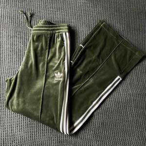 Supersköna Adidas byxor i velour, endast testade aldrig använda. Vida ben, gröna med vita detaljer & dragkedjor i fickorna.  Nypris runt 700kr tror jag.