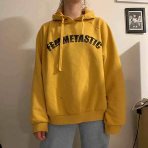 Senapsgul hoodie från Gina tricot med texten ”femmetastic”. En liten fläck, annars i gott skick 