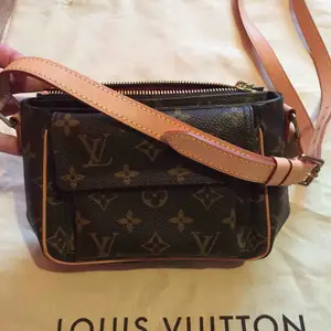 Louis Vuitton Viva Cite PM Cross-Body Bag. Monogram, natural cowhide, adjustable-strap, front snapped pocket and red alcantara lining. Measures 7