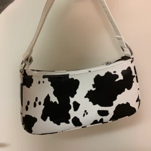 Komönstrad Baguette Väska - En jättefin väska med komönster! Den kan bli stylad vad som helst, och kan även användas för att spicea upp en outfit! Den köptes här på Plick för 220kr och jag säljer den nu för 120kr inklusive frakt. Priset kan diskuteras vid snabb affär och jag kan frakta över hela landet :) Hör av dig vid frågor!!