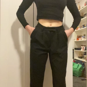 Svarta kostymbyxor  - Svarta jättesköna kostymbyxor! De är pösiga upptill och är lite som mom-jeans och går nedåt till benen. Jag är 166cm och de går ner till fotanklarna. Använda en gång då jag redan har ett par kostymbyxor💗 Säger återigen super sköna!