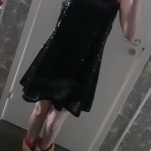 Festklänning  - Såå himla fin svart glittrig festklänning från Nelly som hängt i garderoben alldeles för länge och längtar efter en ny ägare😍Den är använd max 4gånger och är i toppskick. Det enda som jag gjort och brukar göra med de flesta kläder är att klippa bort lappen i bak men det kan man pilla bort resten om man vill. Fler bilder kan skickas och fråga gärna om du undrar något. 