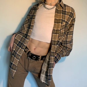 Vintage brun, beige & mörkgrön plaid flanellskjorta button up - Stor vintage plaid flanellskjorta i olika nyanser av brun, beige, vit och mörkgrön med en ficka på vänster bröst och assnygga knappt i olika nyanser av brun 🧺 Vad jag älskar mest med denna skjortan är inte bara de neutrala färgerna som går att matcha med vad som helst (speciellt bruna/beiga byxor/ jeans, flera halsband för att göra outfiten till det lilla extra och ett par mörka kängor) utan också att det är ett vardagligt plagg med en extra edge för att göra din outfit ännu intressantare! 