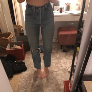 Levi’s ribcage - Ett par blåa ribcage från Levi’s. Hål vid vänster knä. Väldigt höga i midjan, med knappar och inte dragkedja. Storlek 27.