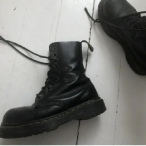 Vintage Dr Martens 1919 - Ett par vintage Dr Martens 1919 gjorda i läder med stålhätta. De är ca 3 cm höga i sulan och 4cm höga vid klacken. De är i begagnat skick och jag köpte dom här på plick, dom är jättefina med en chunky passform men var tyvärr för små för mig. Eftersom dom här behöver ett besök hos skomakaren så säljer jag billigt och bjuder på frakten! (Kan också tänka mig att byta emot skor i strl 38🖤)