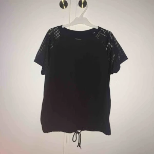  - Sportig t-shirt med nätdetaljer på axlarna och knytning i midjan (se bilderna)! Passar både att träna i som till vardags. Skickar gärna men då tillkommer fraktkostnad.