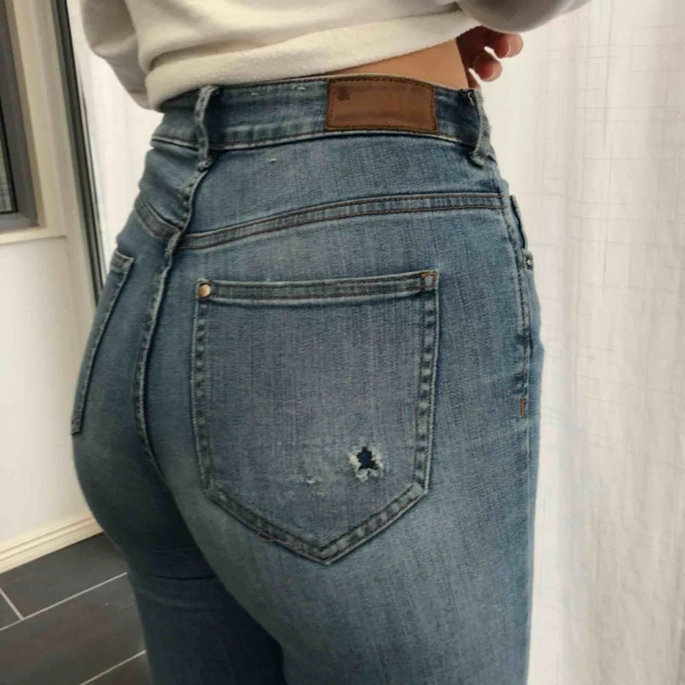 Tighta ljusblåa jeans från H&M med slitage på ena fickan. Använda några få gånger.. Jeans & Byxor.