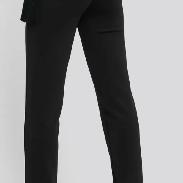 En par svarta kostymbyxor från NA-KD med slits där nere, säljer för 200kr. Storlek 44. (köparen står för frakt) säljer pga blivit för stora 🌸🌸. Jeans & Byxor.