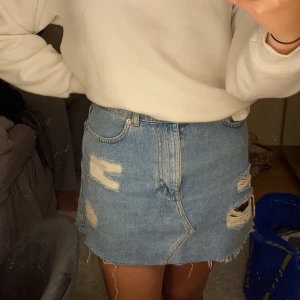 Jeanskjol - Snygg jeanskjol med slitningar från pull&bear. Strl S-M