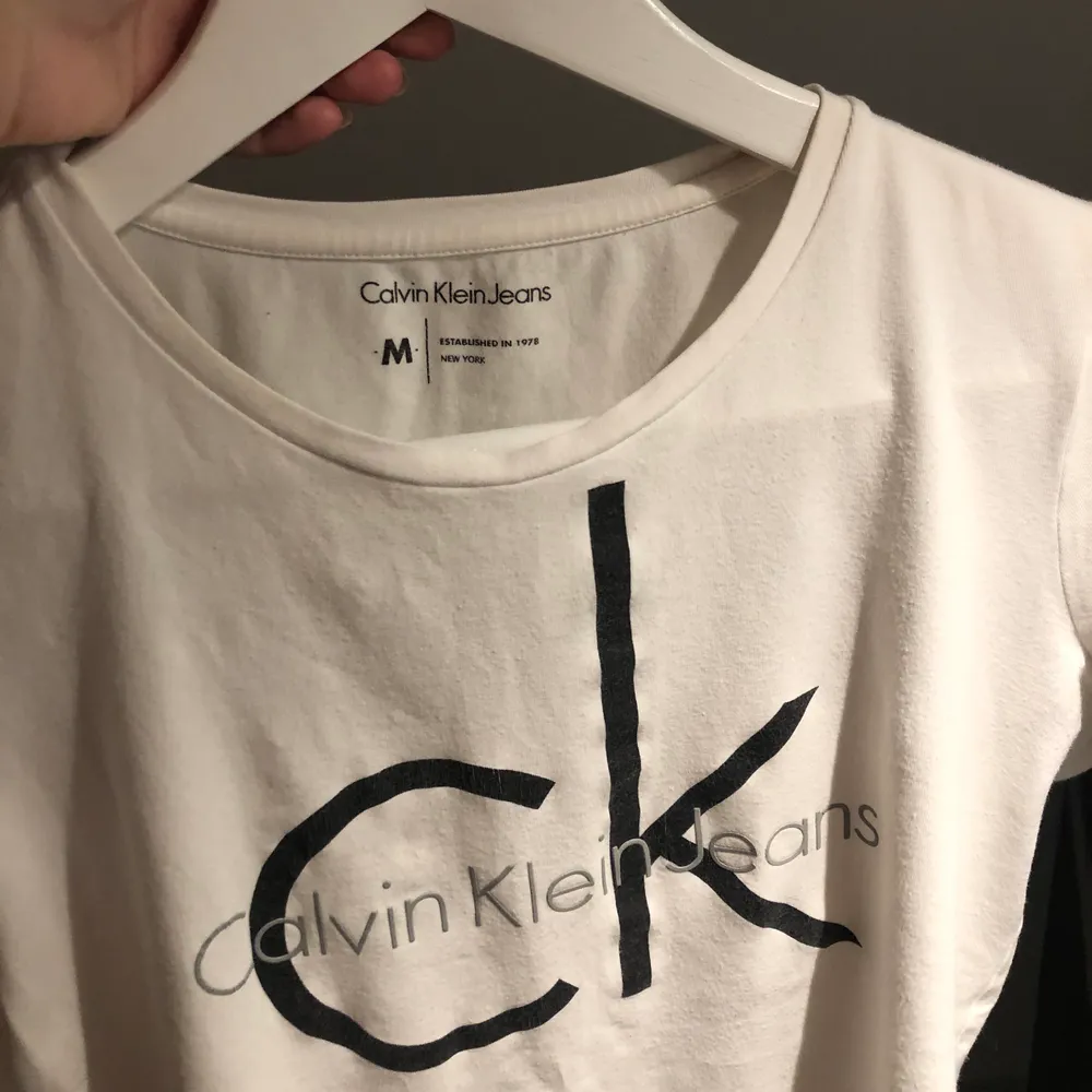 Säljer denna vita Calvin Klein T-shirt (ÄKTA) eftersom den är köpt för flera år sedan och har växt ur den. Inte mycket använd. . T-shirts.
