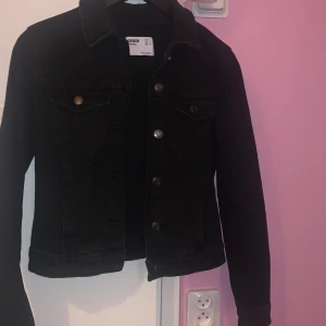 Svart kort jeansjacka - En svart enkel kort jeansjacka. Den är köpt från affären Bershka i London och jag har knappt använt den. Den är i storlek S men är ganska liten så den passar både xxs/xs/s. 