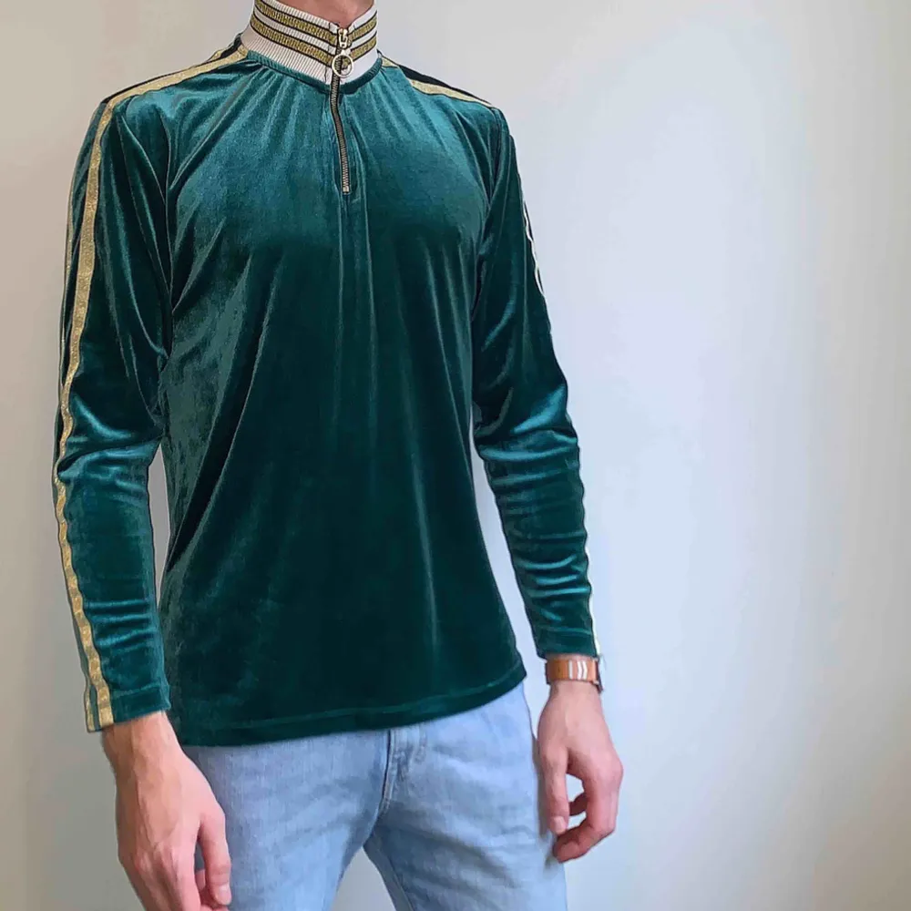 Långärmad t-shirt/polo från ASOS med hög krage och dragkedja i grön velour. Väldigt sparsamt använd. Skick: 8 / 10. Ord pris: 350kr . T-shirts.