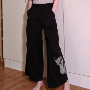  - Coola vida byxor med en drake på ena byxbenet! 🐉 Står barnstorlek 176 på etiketten men passar mig bra som har XS/S i vanligt fall och är 172 cm lång!  100% bomull.   Midjemått: ca 71 cm  Längd: 95 cm 