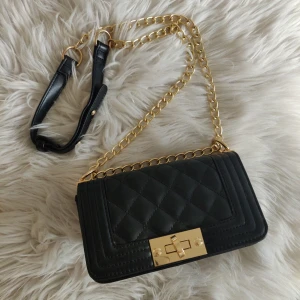  - Väska från Nelly i fakeskin med guldkedja, liten modell.