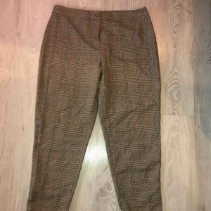 - Storlek: 42, petite.   Rutiga byxor från Bohoo som aldrig är använda (lappen är kvar) i brun/svart och röd.   100 kr + frakt 🥰