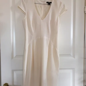  - Benvit H&M-klänning i klassisk modell, med dold dragkedja bak och kort sprund.